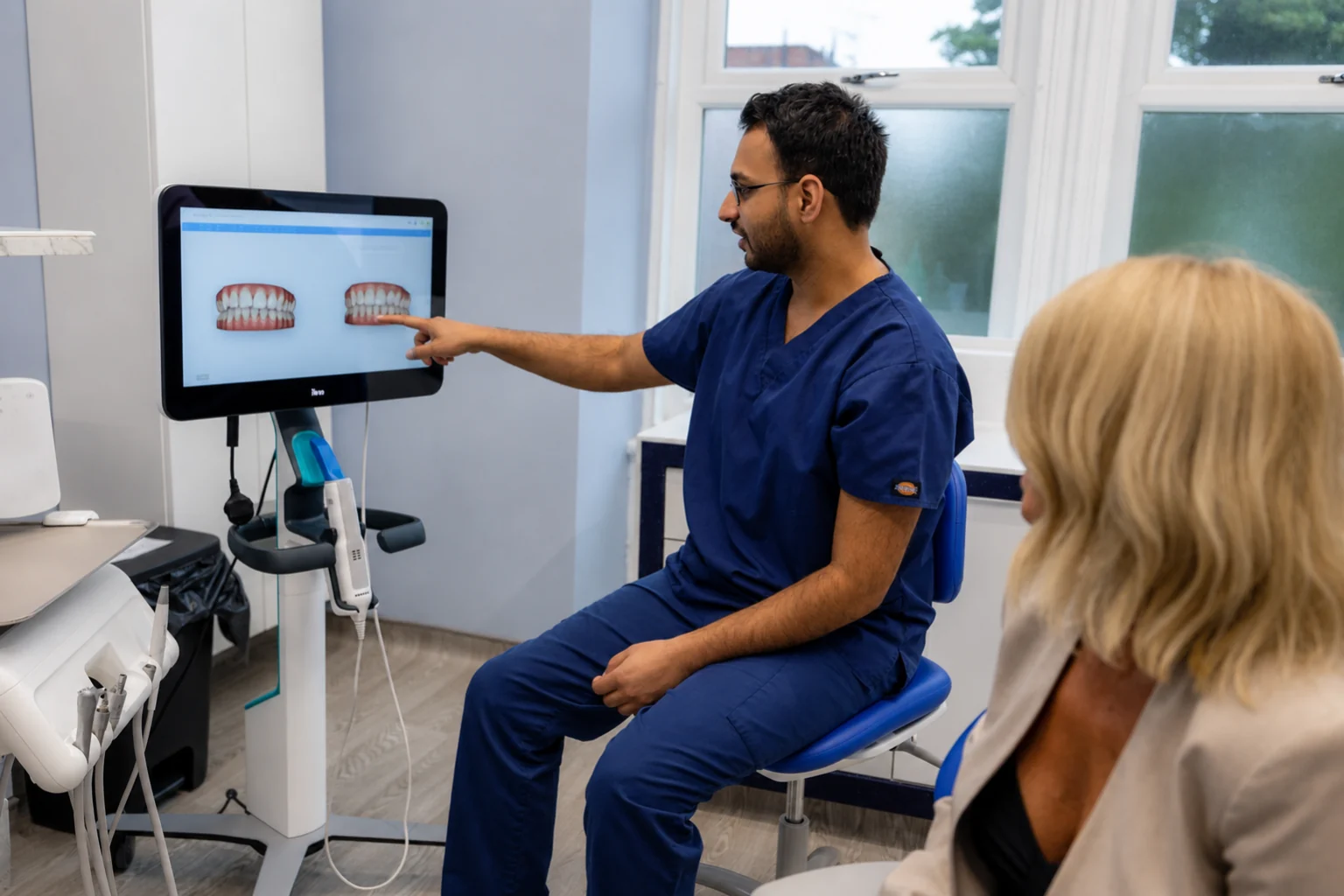 A dentist showing a patient a digital scan of their teeth